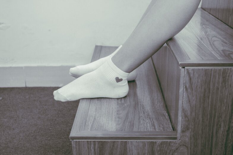 person wearing pair of foot socks sitting on staircase